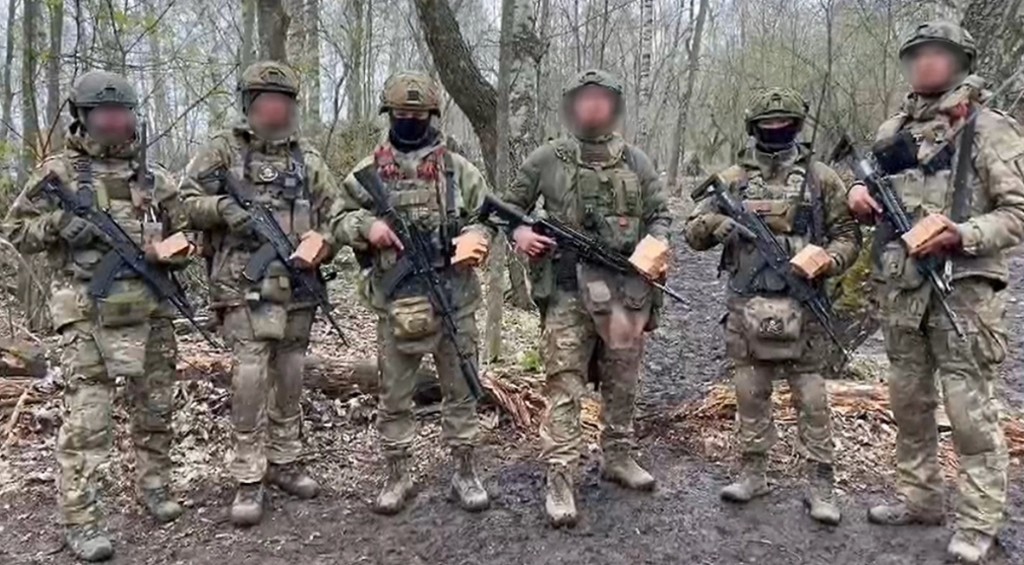 Группа бойцов в экипировке с гуманитарными посылками в лесу